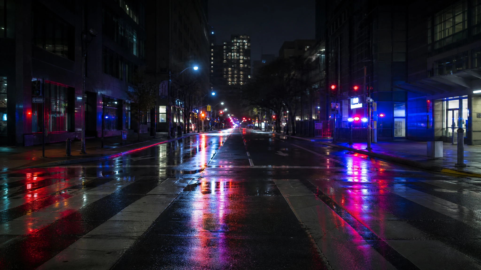 Luces policiales reflejadas en una calle urbana vacía durante la noche