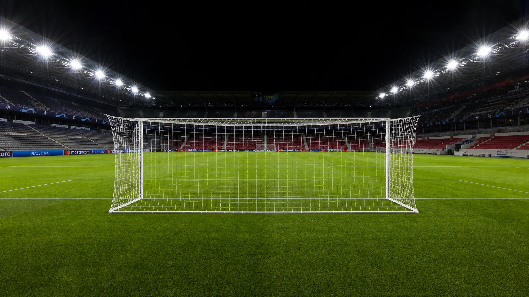 Portería vacía en un campo de fútbol profesional con césped verde